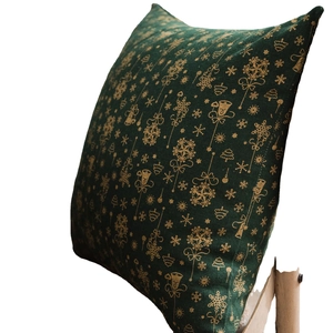 Green Christmas pillow case with golden snowflake and bell patterns on fabric