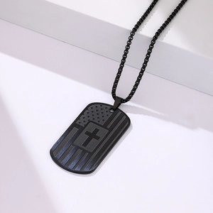 Detailed view of black stainless steel dog tag with American flag and cross engraving