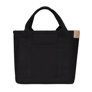 Detail view of the durable black canvas fabric and side accent label on this handbag