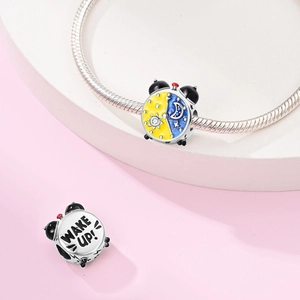 Detailed view of silver alarm clock charm with sun, moon enamel and Wake Up engraving