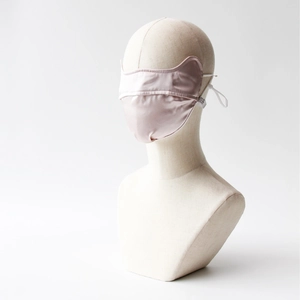 Detailed side view of pink silk sun mask on model showing luxurious fabric texture
