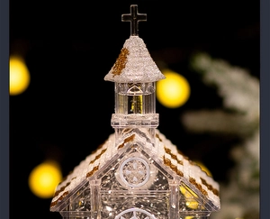 Macro shot of a glowing crystal church music box with gold glitter and warm bokeh lights