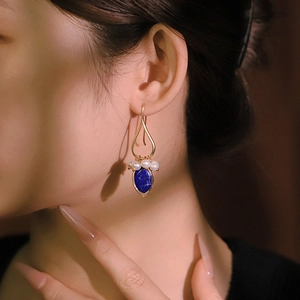 Elegant gold drop earrings featuring natural white pearls and blue lapis lazuli gemstones