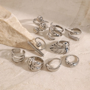 Minimalist silver stainless steel geometric rings set on natural stone background