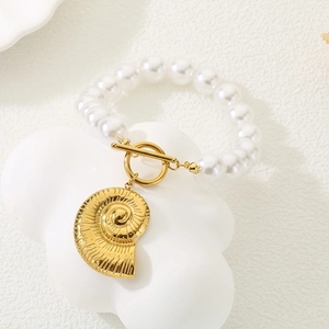 Gros plan détaillé d'un bracelet en perles blanches avec pendentif coquillage doré et fermoir