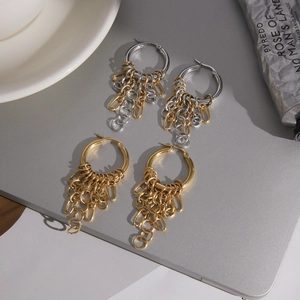Minimalist 18K stainless steel tassel earrings in gold and silver mix on grey surface