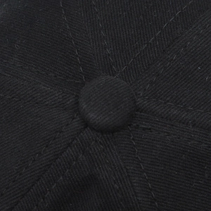 Détail de la couronne à 6 panneaux et du bouton en tissu d'une casquette en coton noir