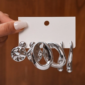 Detailed view of six-piece silver geometric stud earrings on a display card