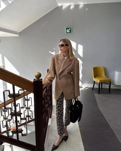 Détail d'un blazer camel surdimensionné et d'un pantalon léopard dans un style urbain chic