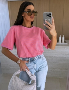 Selfie miroir montrant un t-shirt rayé rose à manches courtes et un jean bleu clair