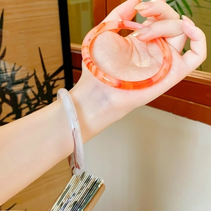 Close-up of new Chinese style round bangles with agate texture and amber floral patterns