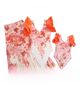 Detailed view of floral bikini set with orange ruffles and matching sarong skirt