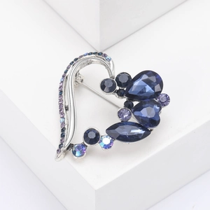 Detailed view of silver heart brooch featuring deep blue and purple crystal gemstones