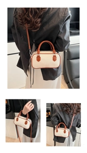 Detail of canvas Boston bag with brown leather trim and silver hardware on model
