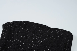 Gros plan détaillé de strass argentés étincelants sur le tissu noir d'une robe moulante