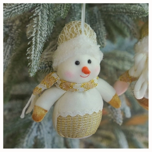 Detail of a plush snowman ornament with champagne gold accents on a green Christmas tree