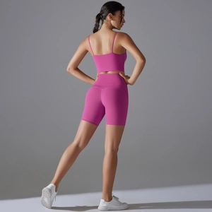 Vista posteriore del set yoga rosa con crop top e pantaloncini da ciclista a vita alta