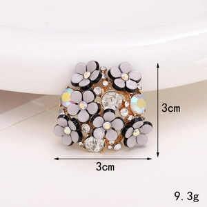 Macro shot of a floral gray brooch with gold plating and sparkling rhinestones 3cm size