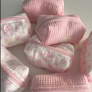 Pink waffle and white bow pattern cosmetic bags in various sizes with zipper closure