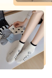 Detail of assorted knitted cotton socks with sheep prints and stripes in cream and blue