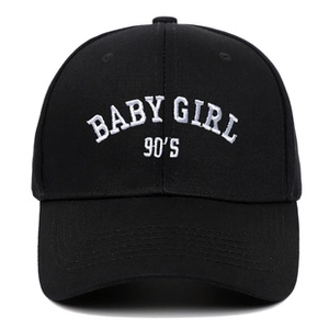 Close-up of white 90'S BABY GIRL embroidery on a black washed cotton baseball cap