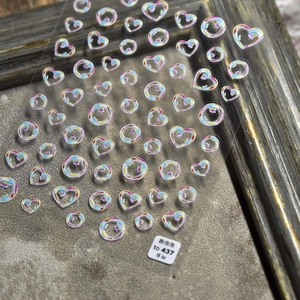 Detail shot of holographic heart and bubble nail art stickers with a pearlescent finish