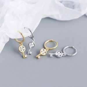 Detailed view of gold and silver S925 sterling silver four-leaf clover key earrings