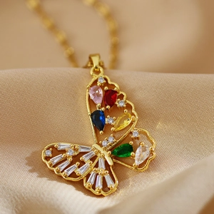 Collier papillon doré chic avec zircons colorés posé sur de la soie satinée