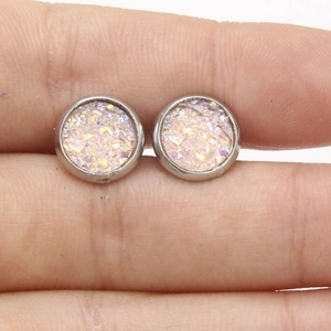 Macro detail of 8mm stainless steel stud earrings with colorful sparkling purple texture