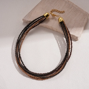 Detailed view of bohemian layered beaded necklace with bronze beads and lobster clasp