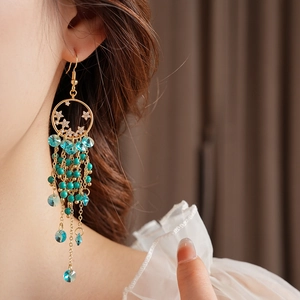Détail de créoles vintage dorées avec perles turquoise et pendentifs en cristal bleu