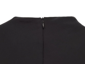 Close-up of invisible back zipper and neckline detail on a black long sleeve mini dress