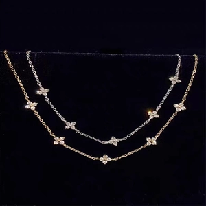 Detailed macro shot of clover necklaces with micro-set zircons in gold and silver finish