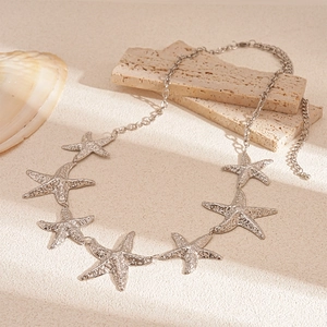 Detailed close-up of metallic starfish charms with hammered texture and beach decor