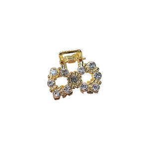 Mini gold bow hair claw clip with sparkling rhinestones for elegant styling