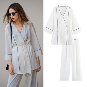 Détails d'un ensemble de détente blanc style kimono avec liseré noir et ceinture nouée