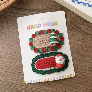 Details von handgestrickten Weihnachtshaarspangen mit Weihnachtsmann und Baum Motiv