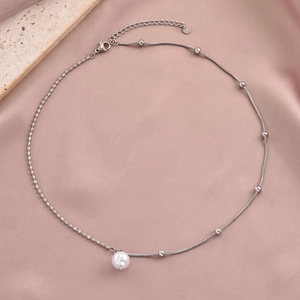 Elegant silver stainless steel pearl pendant necklace on soft pink silk fabric texture