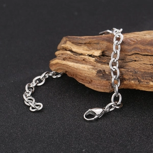 Close-up of silver stainless steel cable chain with robust lobster clasp on wood