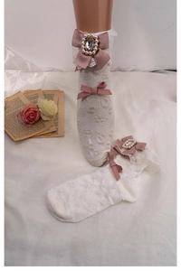 Detail of white lace socks featuring pink bows, pearls, and crystals in Lolita style