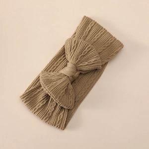Detailed cable knit texture of a soft khaki baby headband with a large bow detail