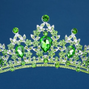 Close-up of sparkling green teardrop rhinestones on an elegant silver bridal crown