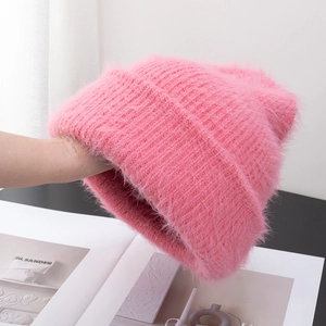 Detail view of pink fuzzy knit beanie showing soft plush texture and thick yarn material
