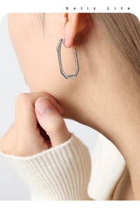 Model wearing minimalist silver geometric octagonal earrings with high-polish finish