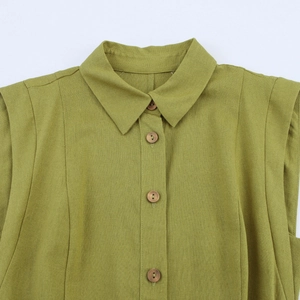 Close-up of olive green linen sleeveless shirt with wooden buttons and collar detail