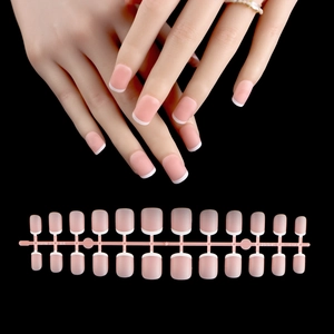 Detailed view of French tip press-on nails set in nude pink with white smile lines