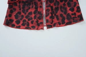 Close-up of red and black leopard print mesh fabric with neat stitching on the hem