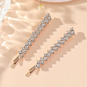 Close-up of dual-row crystal rhinestone hairpins on golden base with floral accent