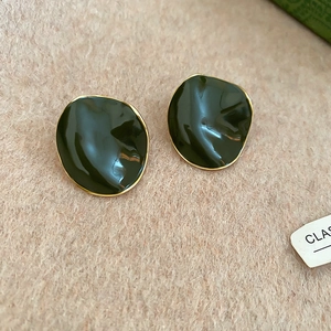 Macro detail of dark green enamel irregular earrings with thin gold plated edges