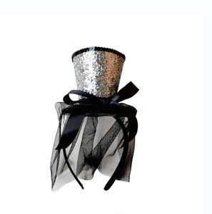 Dettaglio mini cappello con paillettes argento e velo in rete nera per feste